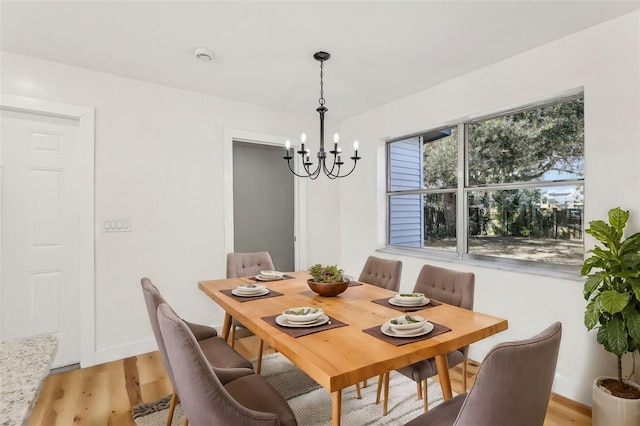 dining area featuring a notable chandelier and light hardwood / wood-style floors