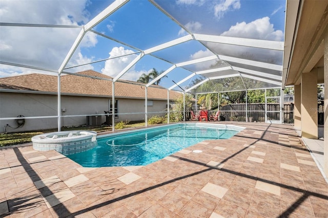 view of swimming pool featuring a patio area, a lanai, and an in ground hot tub