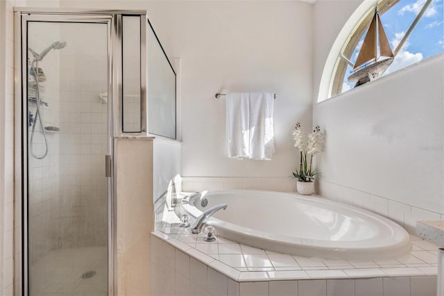 bathroom featuring separate shower and tub