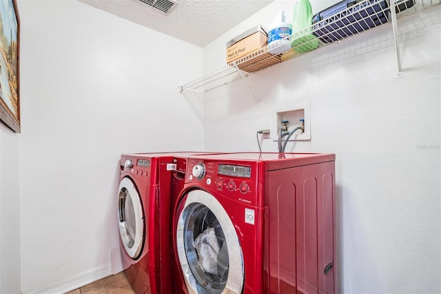 washroom featuring washer and dryer and a textured ceiling