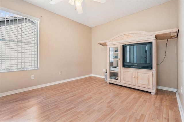 unfurnished living room with ceiling fan, light wood-type flooring, and a textured ceiling