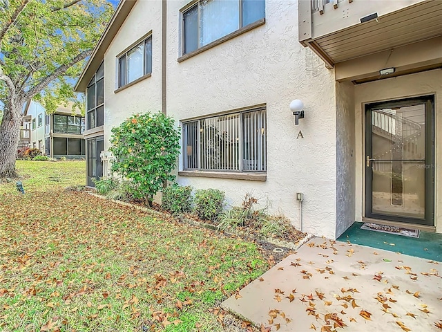 entrance to property with a lawn