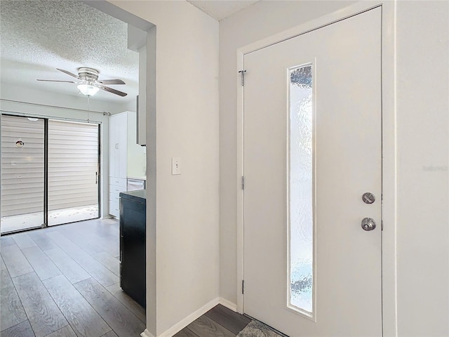 foyer entrance featuring hardwood / wood-style flooring, ceiling fan, and a textured ceiling