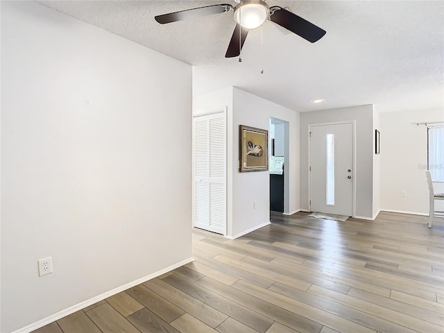 foyer featuring ceiling fan, hardwood / wood-style floors, and a textured ceiling