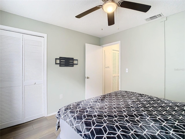 bedroom featuring wood-type flooring, a closet, and ceiling fan