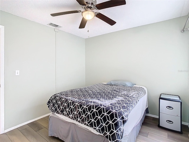 bedroom with ceiling fan and wood-type flooring