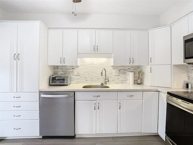 kitchen featuring backsplash, sink, white cabinetry, and stainless steel appliances