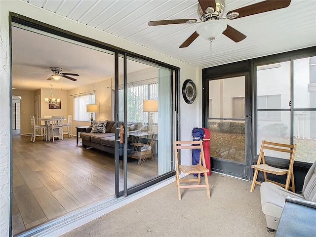 sunroom / solarium with ceiling fan with notable chandelier