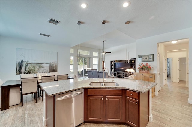 kitchen with stainless steel dishwasher, ceiling fan, a center island with sink, and sink