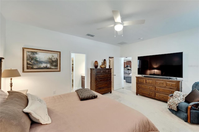 bedroom with ensuite bathroom, ceiling fan, and light carpet