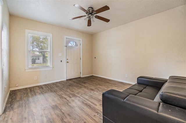 living room featuring ceiling fan, wood-type flooring, and a textured ceiling