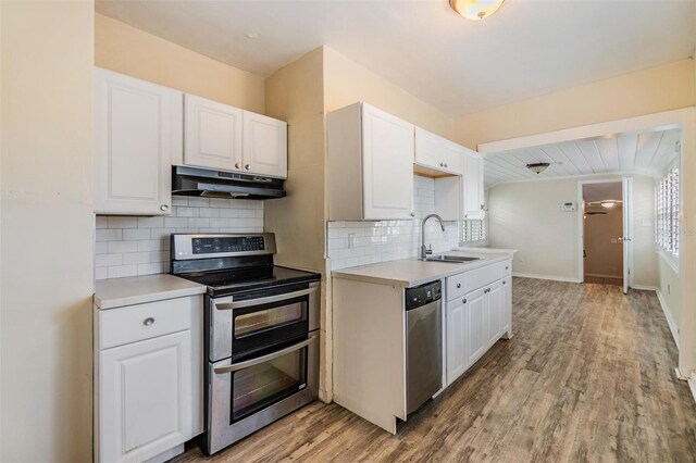 kitchen featuring white cabinetry, sink, decorative backsplash, appliances with stainless steel finishes, and light wood-type flooring