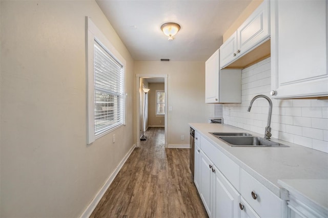 kitchen with decorative backsplash, dark hardwood / wood-style floors, white cabinetry, and sink