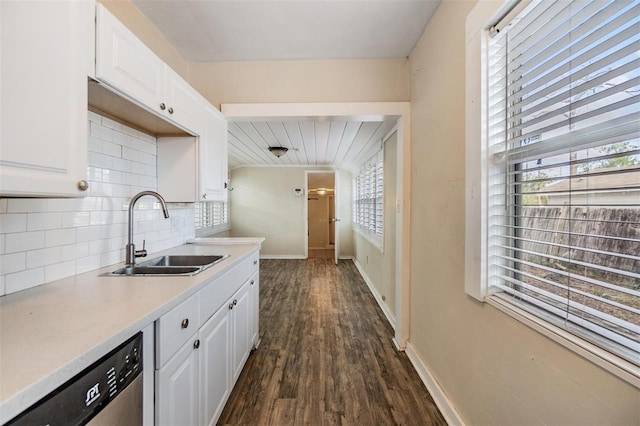 kitchen featuring white cabinets, stainless steel dishwasher, dark wood-type flooring, and sink