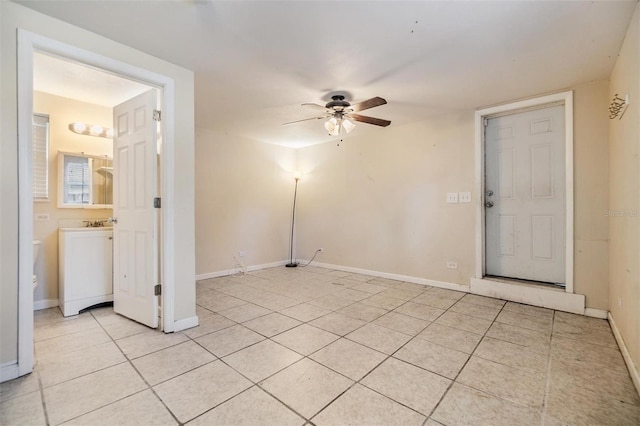 tiled empty room featuring ceiling fan