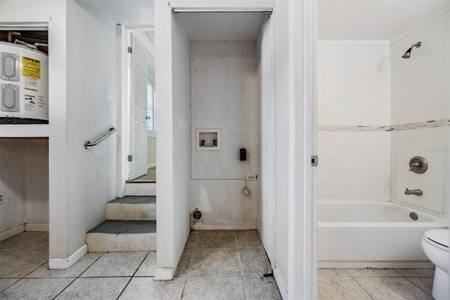 bathroom featuring tile patterned flooring, toilet, electric water heater, and tiled shower / bath