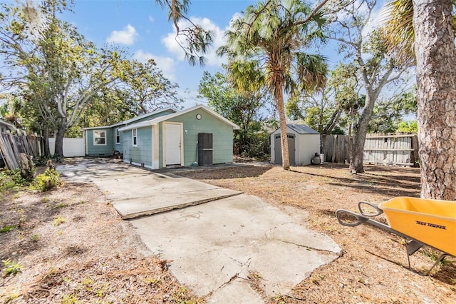 back of property with a patio area and a shed