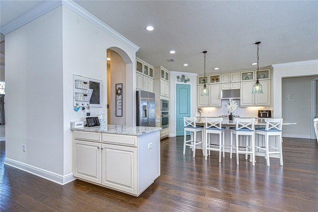 kitchen featuring decorative light fixtures, a center island, ornamental molding, and stainless steel appliances