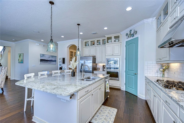 kitchen featuring a kitchen island with sink, a kitchen breakfast bar, sink, appliances with stainless steel finishes, and white cabinetry