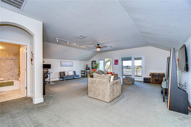 living room featuring carpet, a textured ceiling, ceiling fan, and lofted ceiling