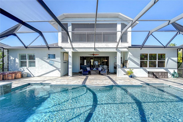 view of swimming pool featuring ceiling fan, a patio area, an outdoor living space, and glass enclosure