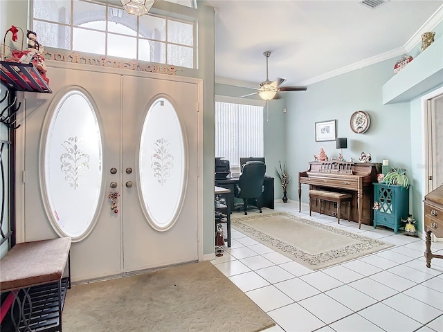 entrance foyer with ceiling fan, light tile patterned floors, and crown molding