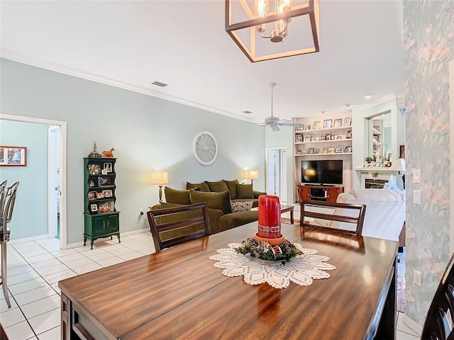 tiled dining space featuring ceiling fan with notable chandelier and crown molding