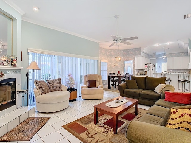 living room with a fireplace, light tile patterned floors, ceiling fan, and ornamental molding