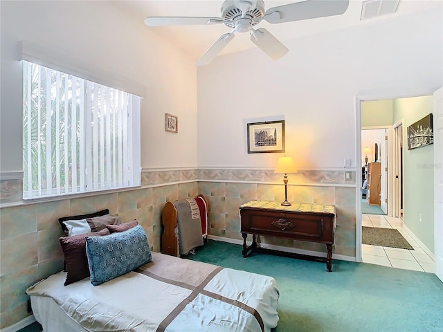 carpeted bedroom with ceiling fan and tile walls