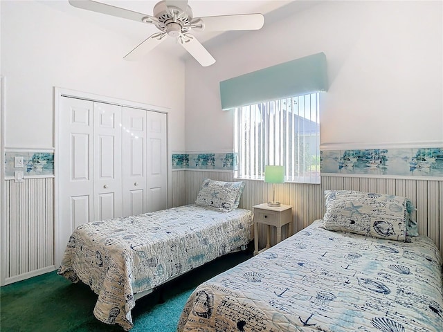 bedroom with dark colored carpet, ceiling fan, and a closet