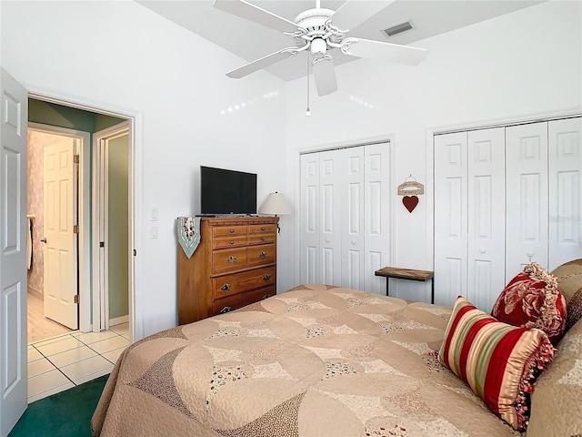 bedroom featuring multiple closets, ceiling fan, and tile patterned flooring