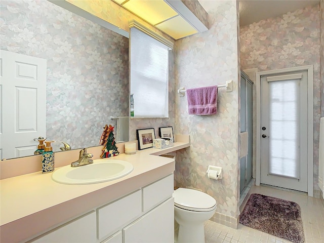 bathroom featuring tile patterned flooring, toilet, an enclosed shower, and vanity