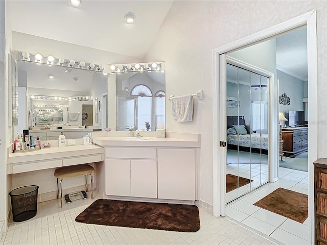 bathroom with tile patterned floors, vanity, and vaulted ceiling