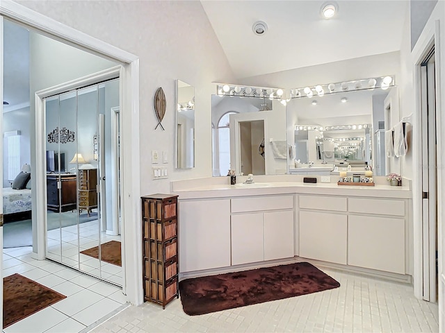 bathroom featuring tile patterned flooring, vanity, and vaulted ceiling