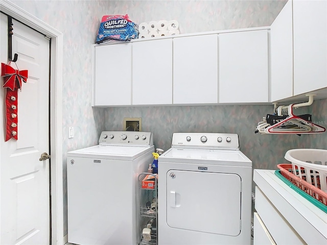 clothes washing area featuring cabinets and independent washer and dryer