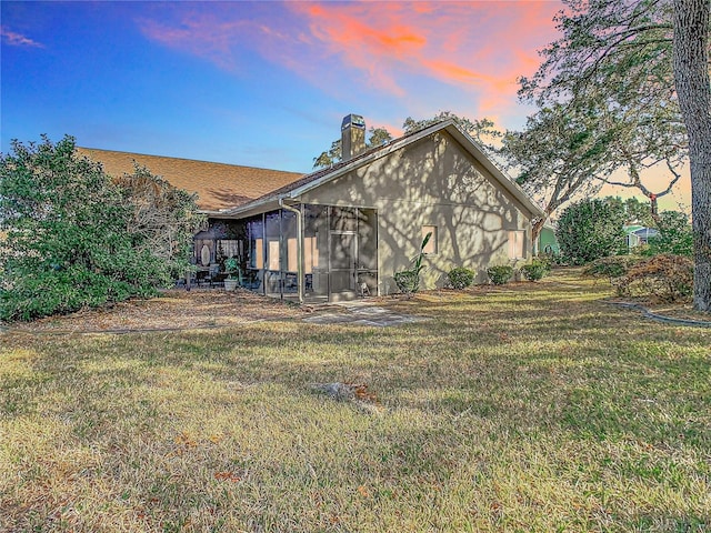 property exterior at dusk featuring a yard