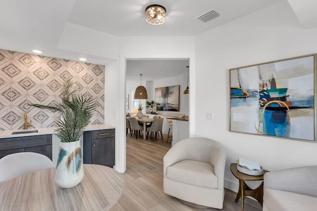 sitting room featuring light hardwood / wood-style flooring and tile walls