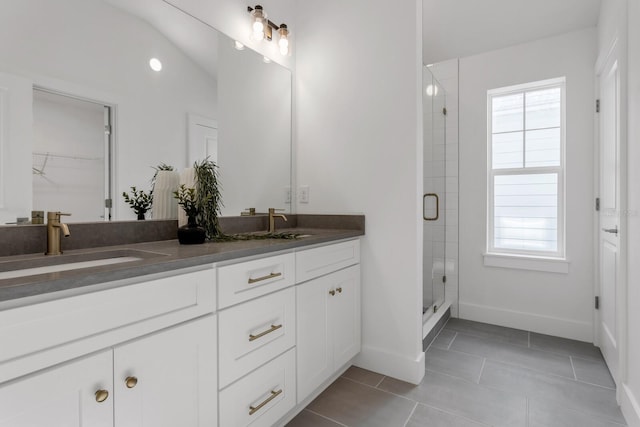 bathroom featuring tile patterned floors, vanity, walk in shower, and vaulted ceiling