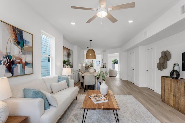 living room with light hardwood / wood-style flooring and ceiling fan