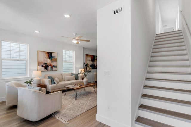 living room featuring ceiling fan, a wealth of natural light, and light hardwood / wood-style flooring