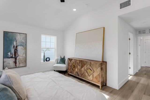 bedroom featuring light wood-type flooring and lofted ceiling