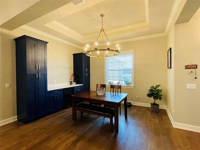 dining area with a raised ceiling, dark hardwood / wood-style flooring, ornamental molding, and an inviting chandelier