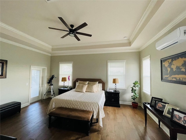 bedroom with hardwood / wood-style flooring, a wall unit AC, multiple windows, and ceiling fan