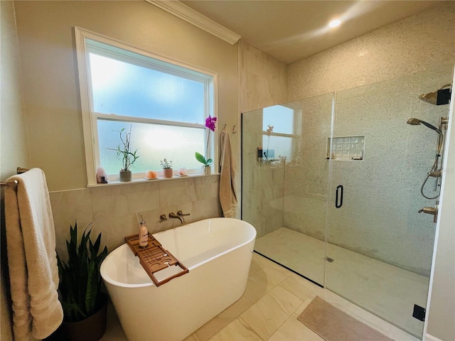 bathroom with crown molding, independent shower and bath, and tile walls