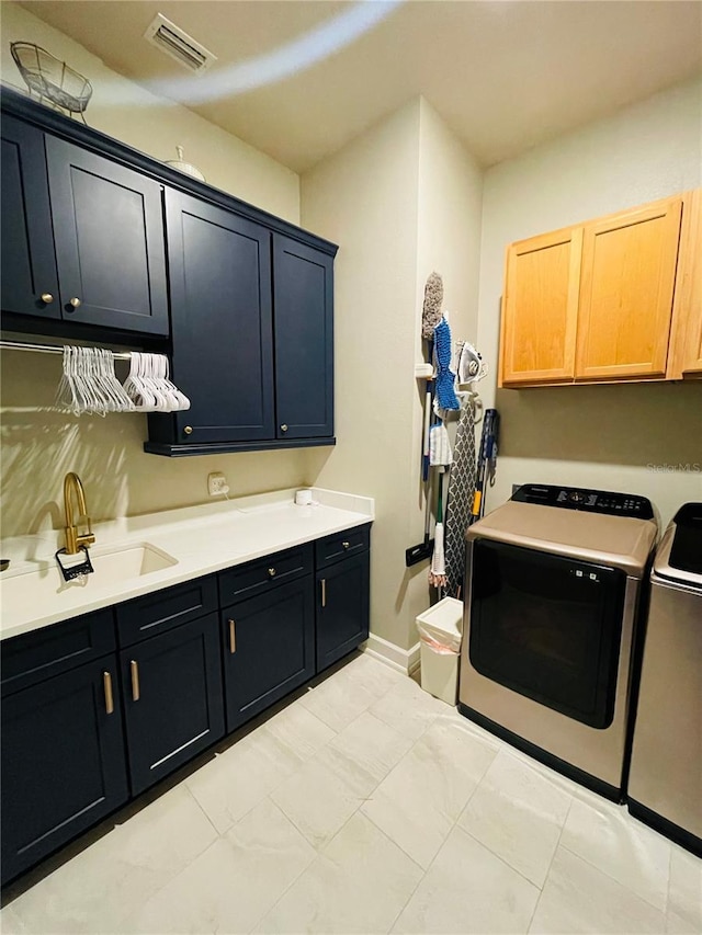 laundry room with cabinets, independent washer and dryer, and sink