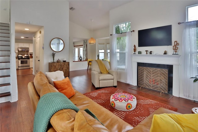 living room with dark hardwood / wood-style floors and high vaulted ceiling