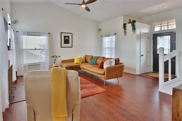 living room with lofted ceiling, dark wood-type flooring, and a healthy amount of sunlight