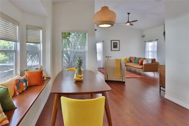 dining room with a high ceiling, dark wood-type flooring, and a healthy amount of sunlight