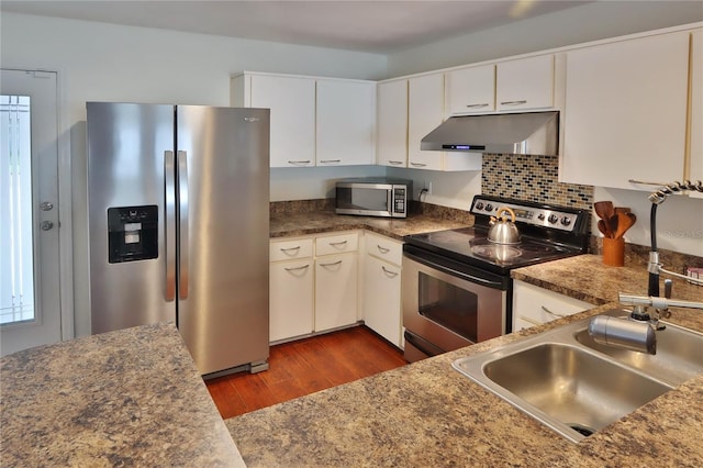 kitchen featuring stainless steel appliances, white cabinetry, and dark wood-type flooring