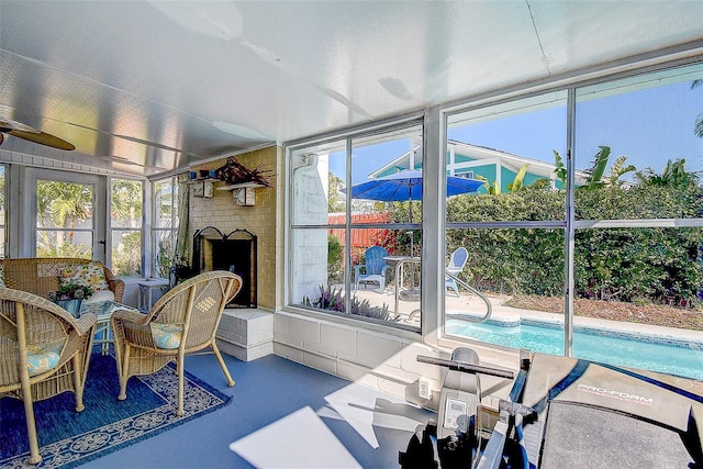 sunroom / solarium featuring a fireplace and ceiling fan